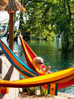 Relax in a hammock at the water's edge at Living Colours Resort