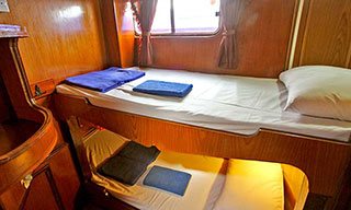 Twin bunk beds in Manta Queen 6's cabins